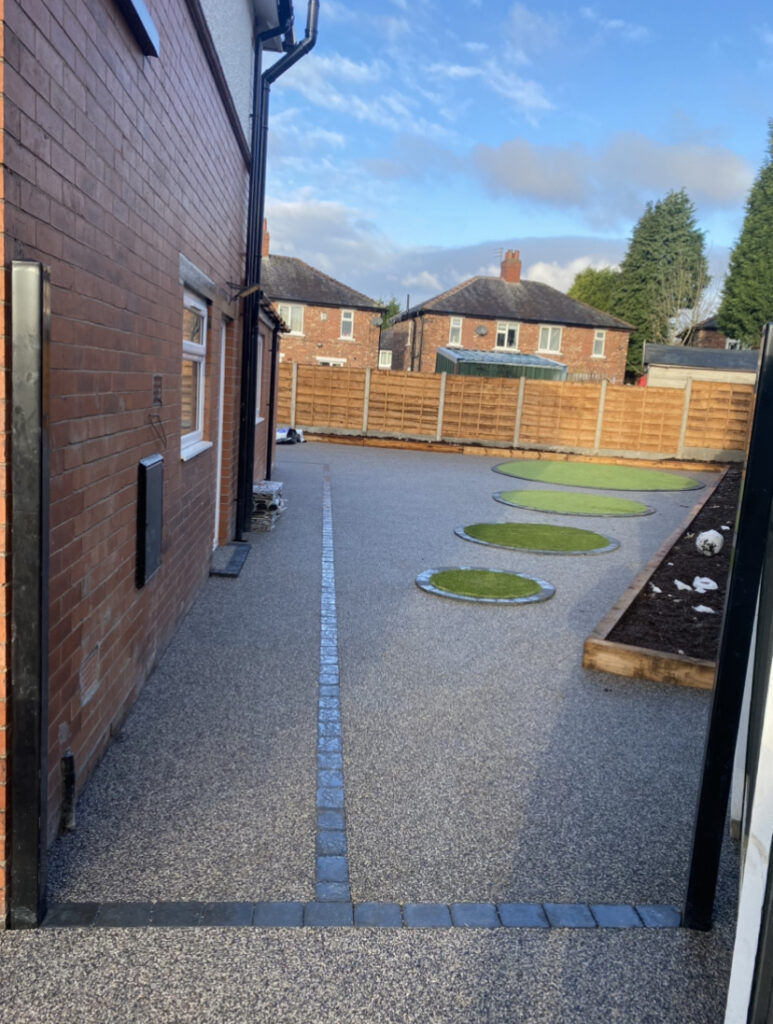 Curved artificial grass feature with charcoal edging and grey resin surfacing