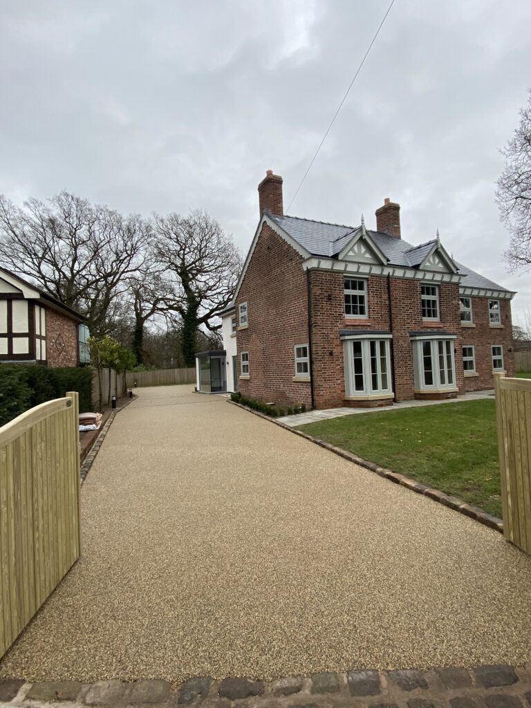 Large natural stone resin driveway outside a country-style home