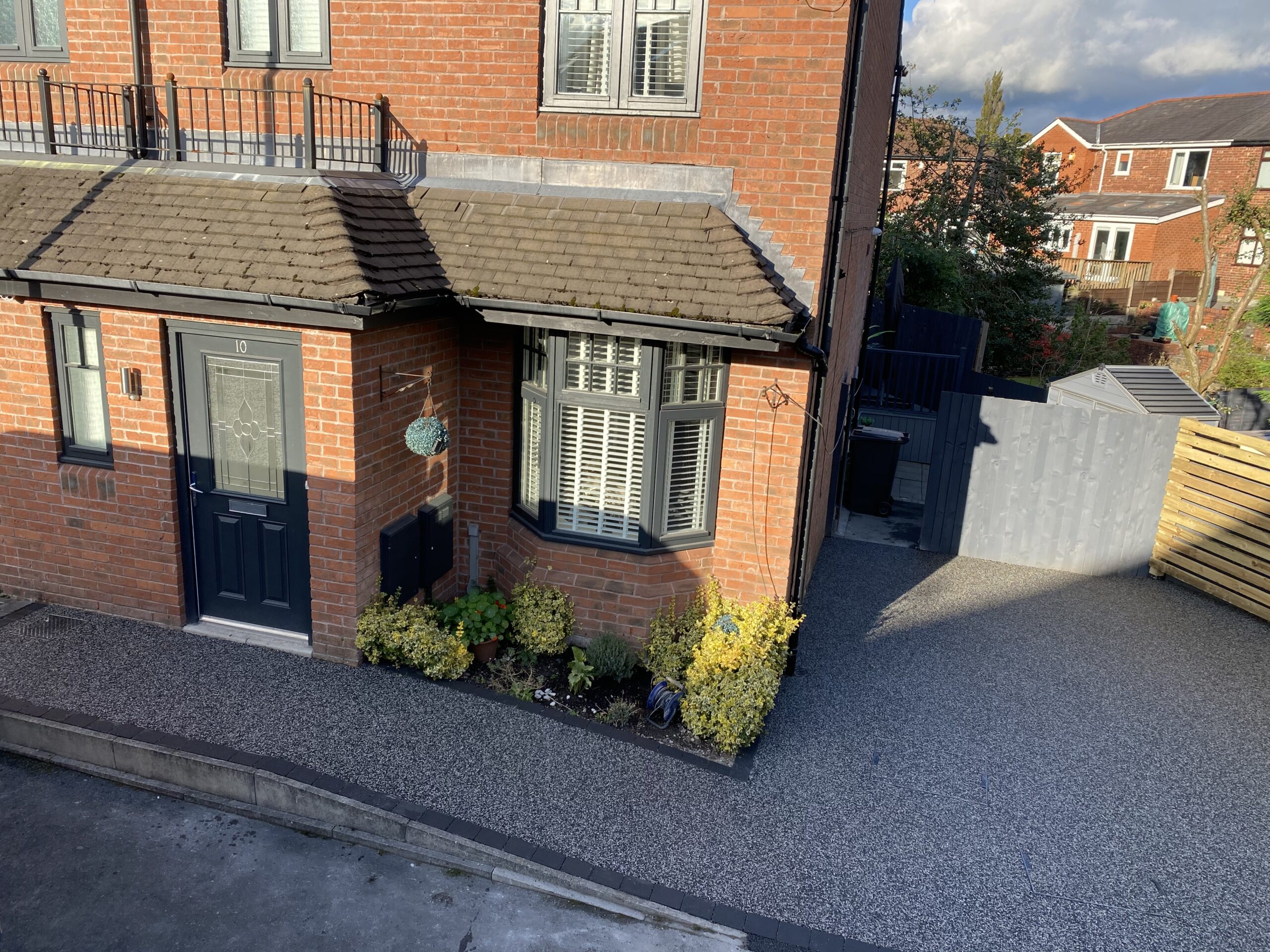 Completed Eclipse resin driveway and paths in Ashton-under-Lyne with charcoal block borders and new fencing