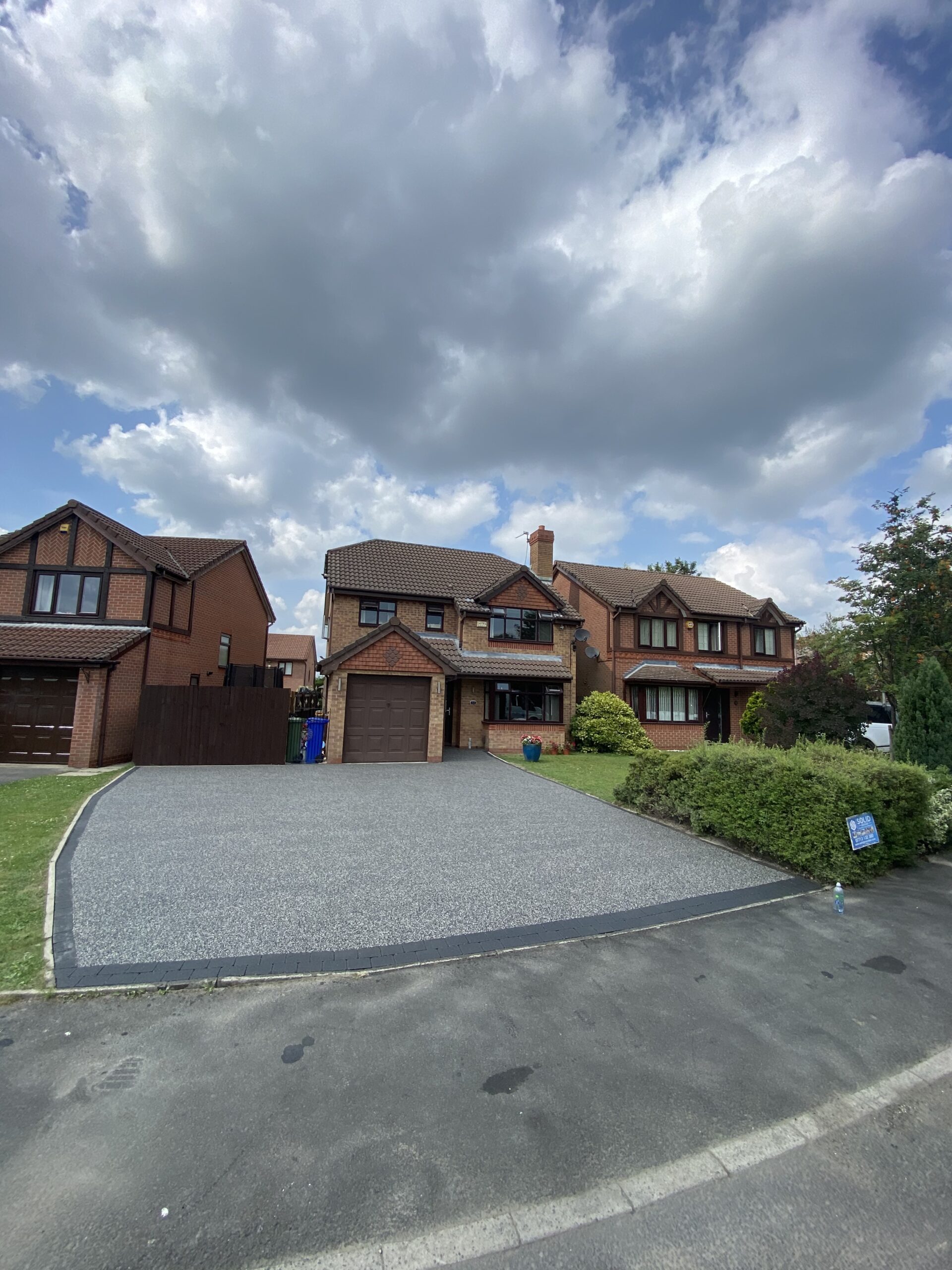 Finished large grey resin driveway in Dukinfield with dark block edging