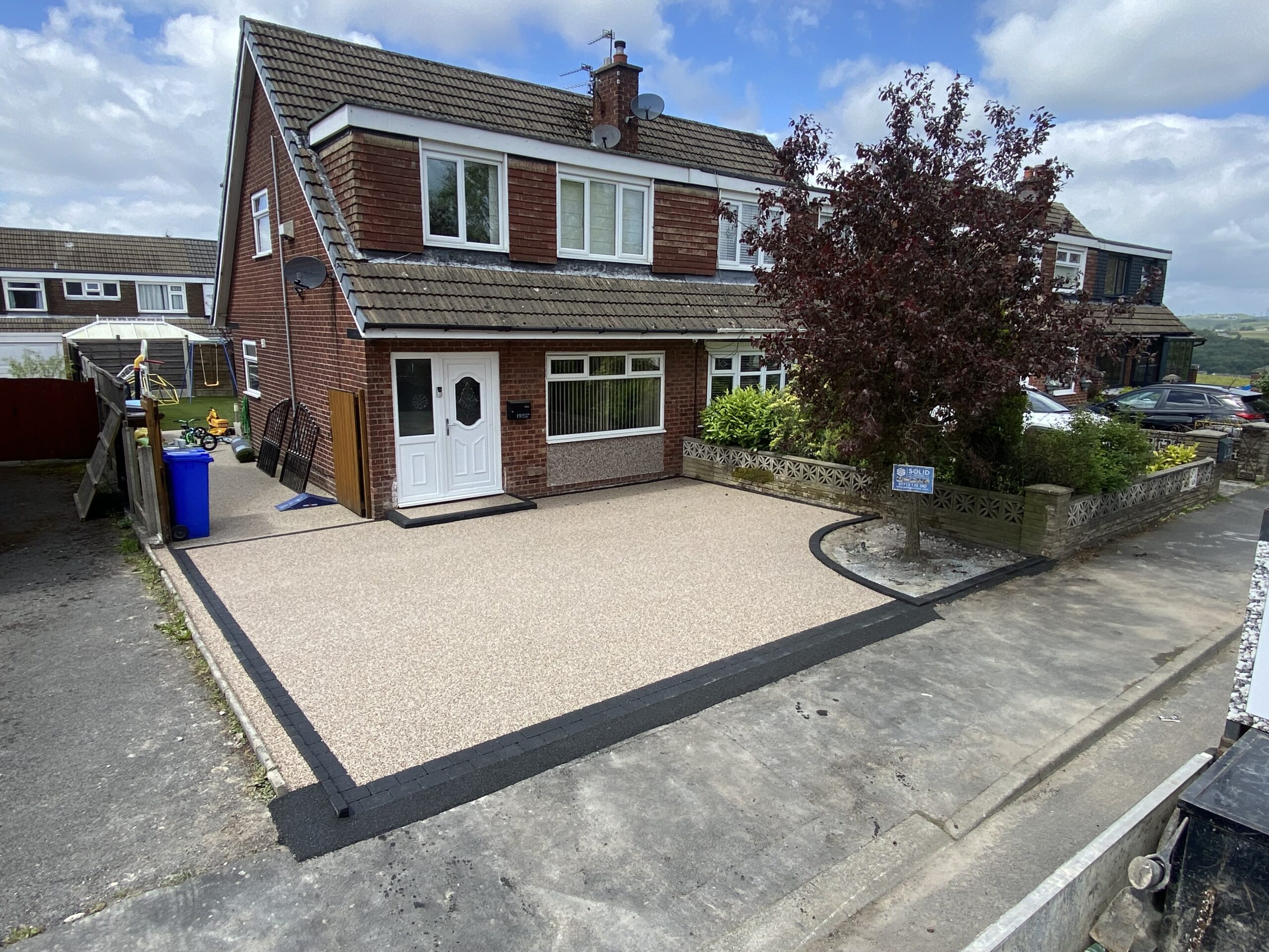 Finished light resin driveway in Dukinfield with dark block border after front garden conversion