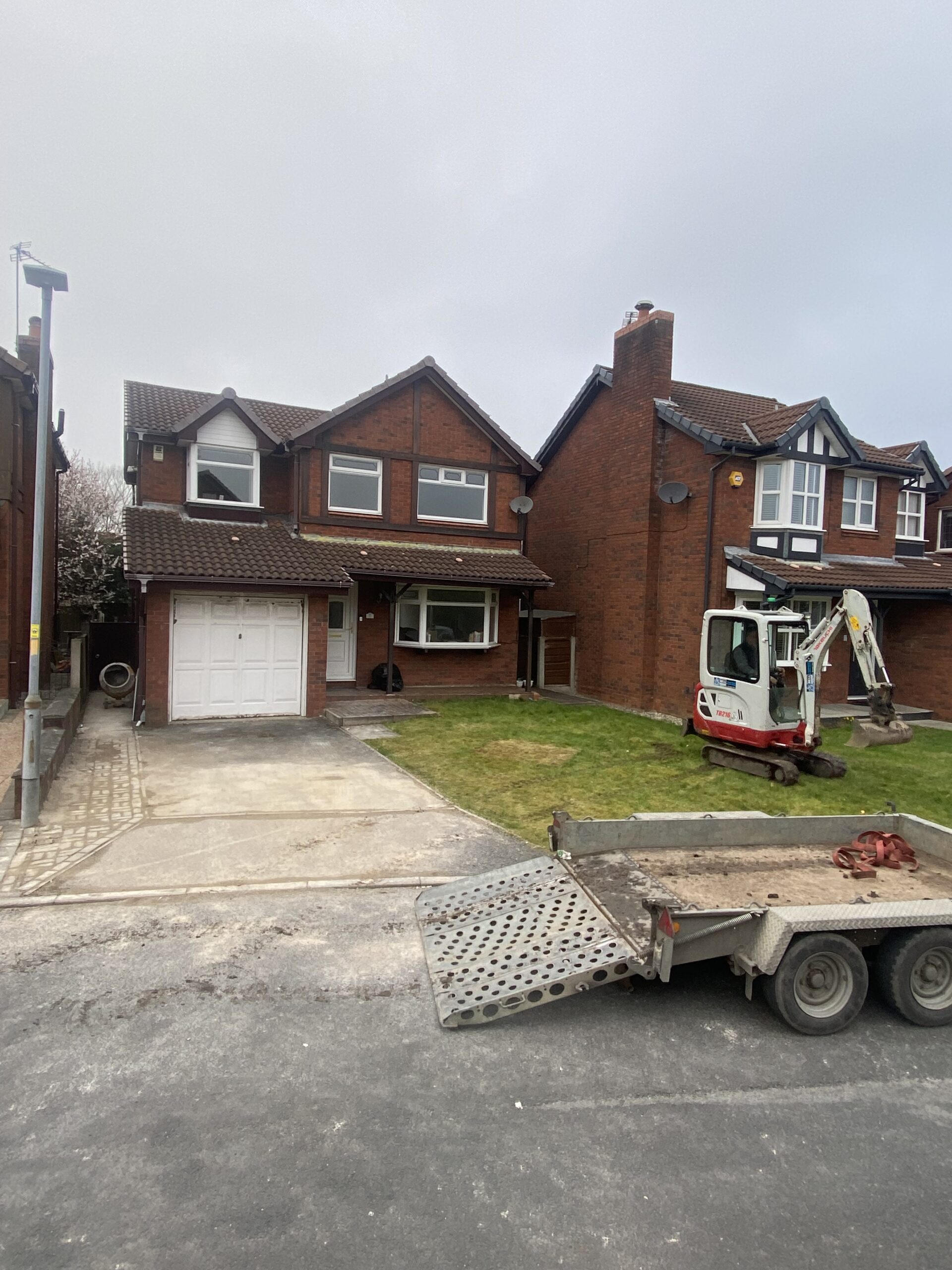 Dukinfield driveway before resin installation showing existing concrete and lawn during excavation