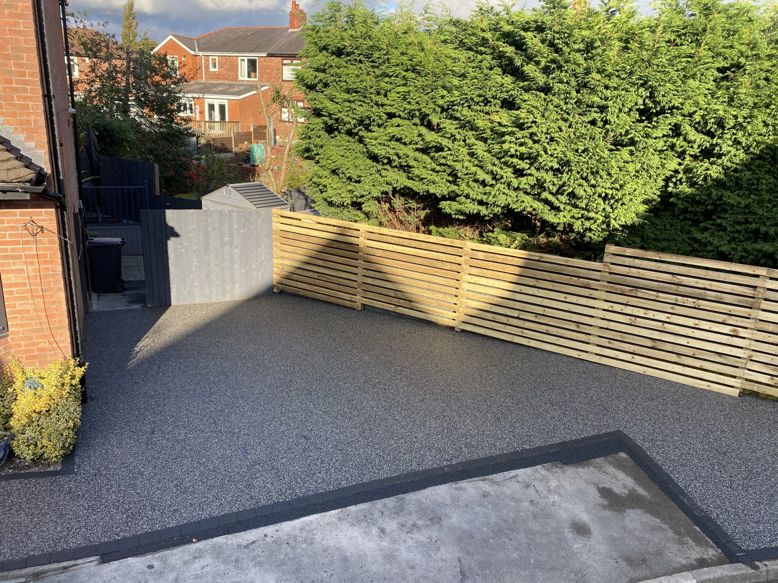 Finished Eclipse resin driveway in Ashton-under-Lyne with charcoal borders and new timber fencing