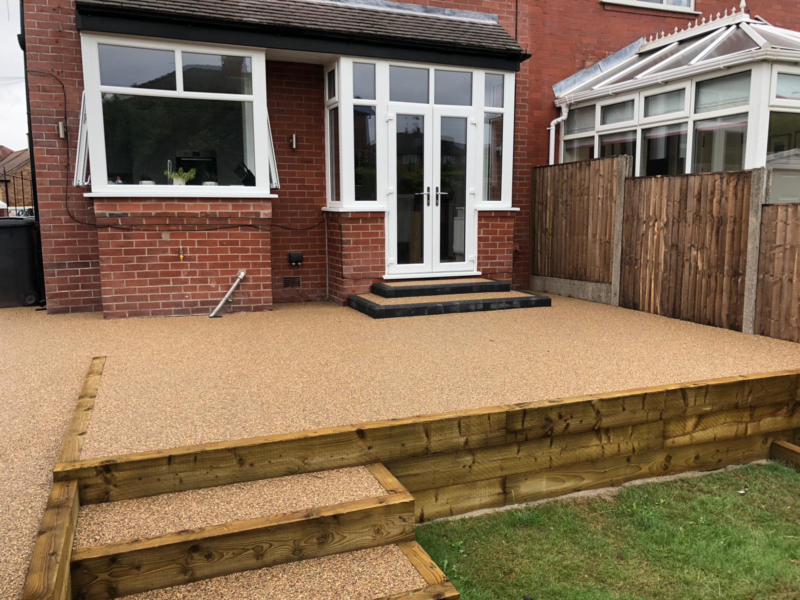 Completed Cappuccino resin patio in Failsworth with timber sleeper border and new charcoal-edged steps