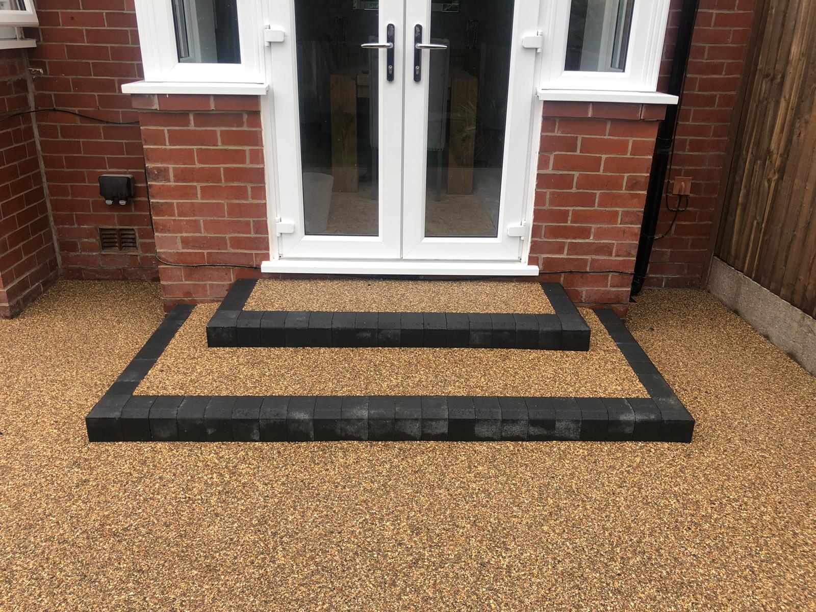 Close view of two new charcoal block-edged steps with Cappuccino resin finish at the Failsworth patio