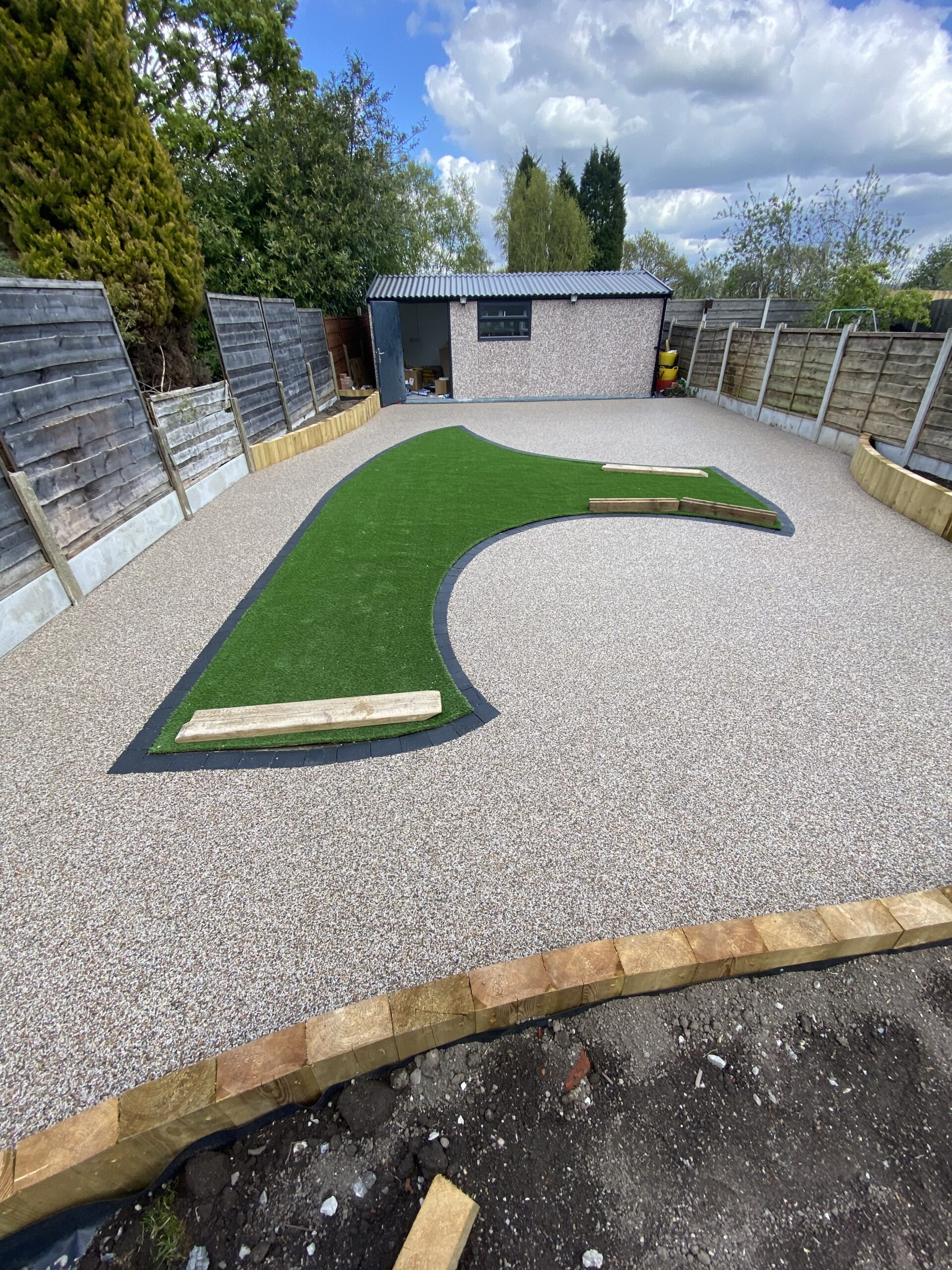 Aurora resin-bound patio with artificial grass and charcoal edging blocks in Heaton Chapel