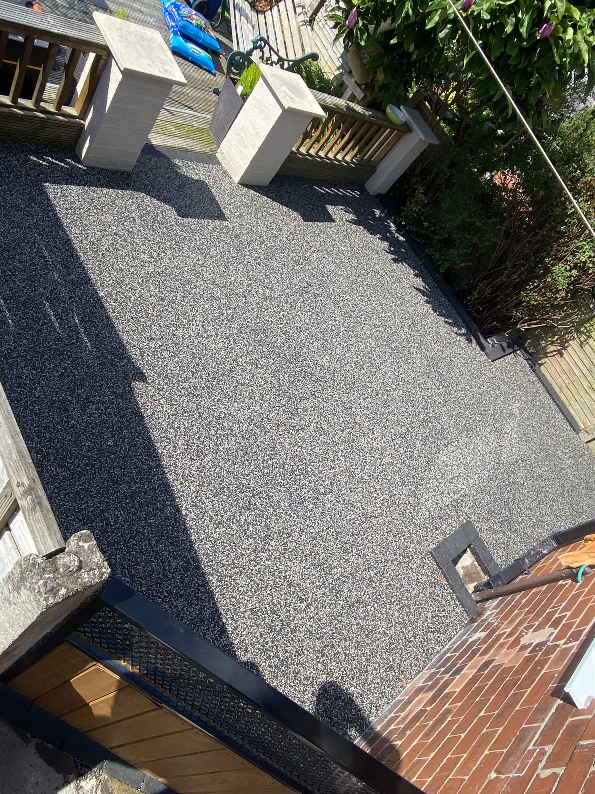 Completed approximately 15m² Eclipse resin patio in Hyde, Tameside, beside existing decking and garden planting