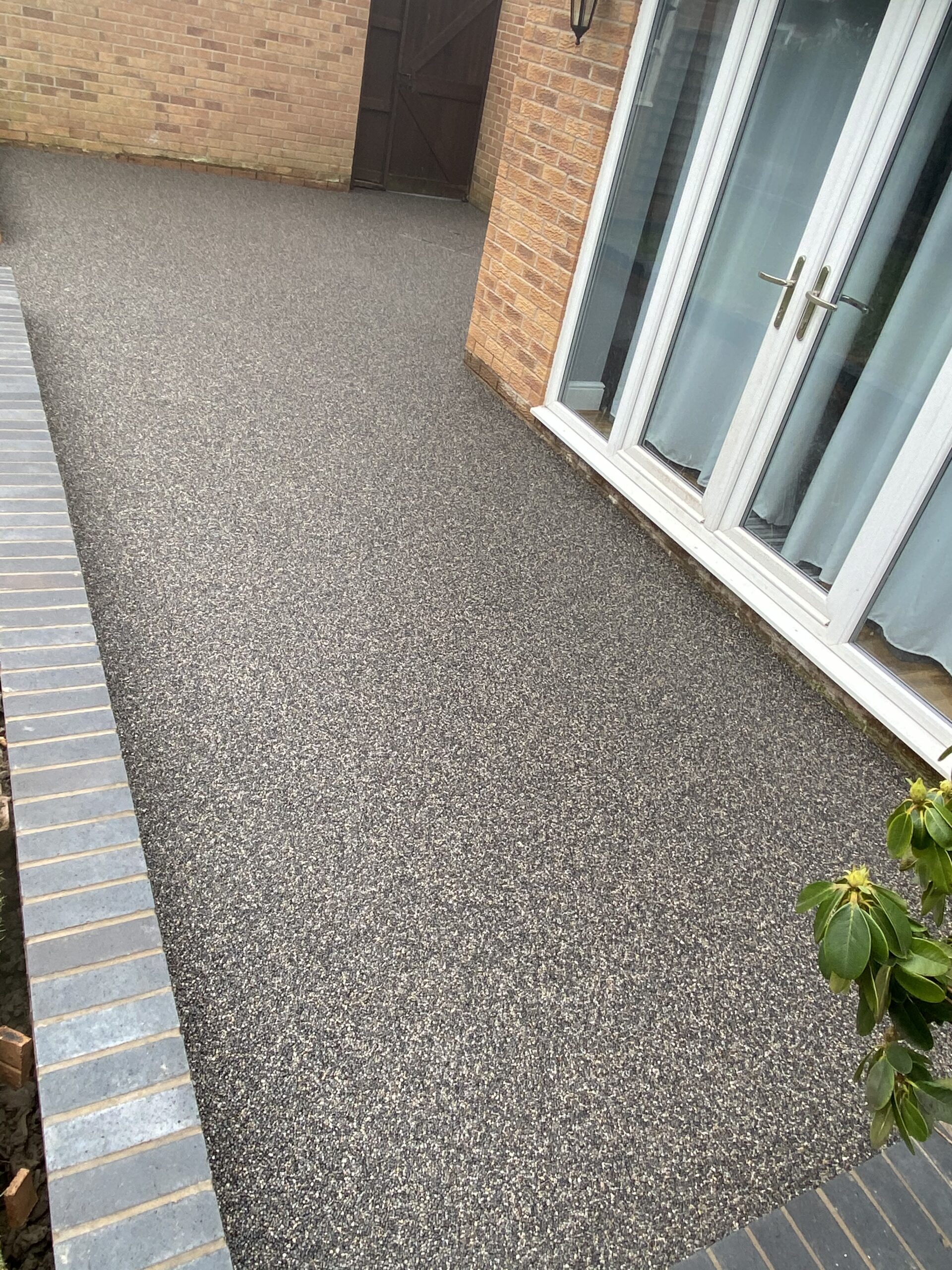 Grey resin patio transformation in Warrington with new brick walls