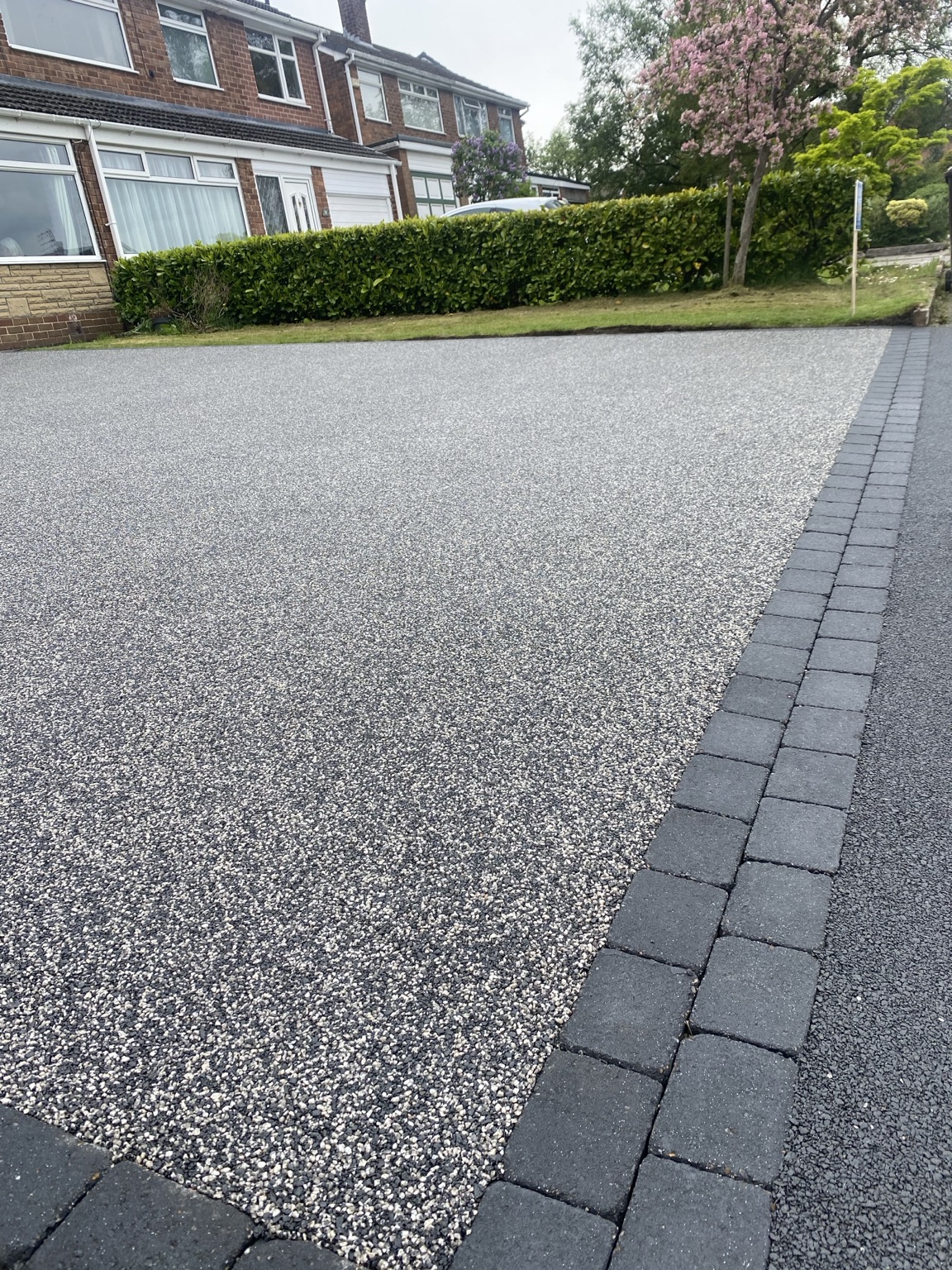 Close-up of a finished resin-bound driveway with charcoal block border