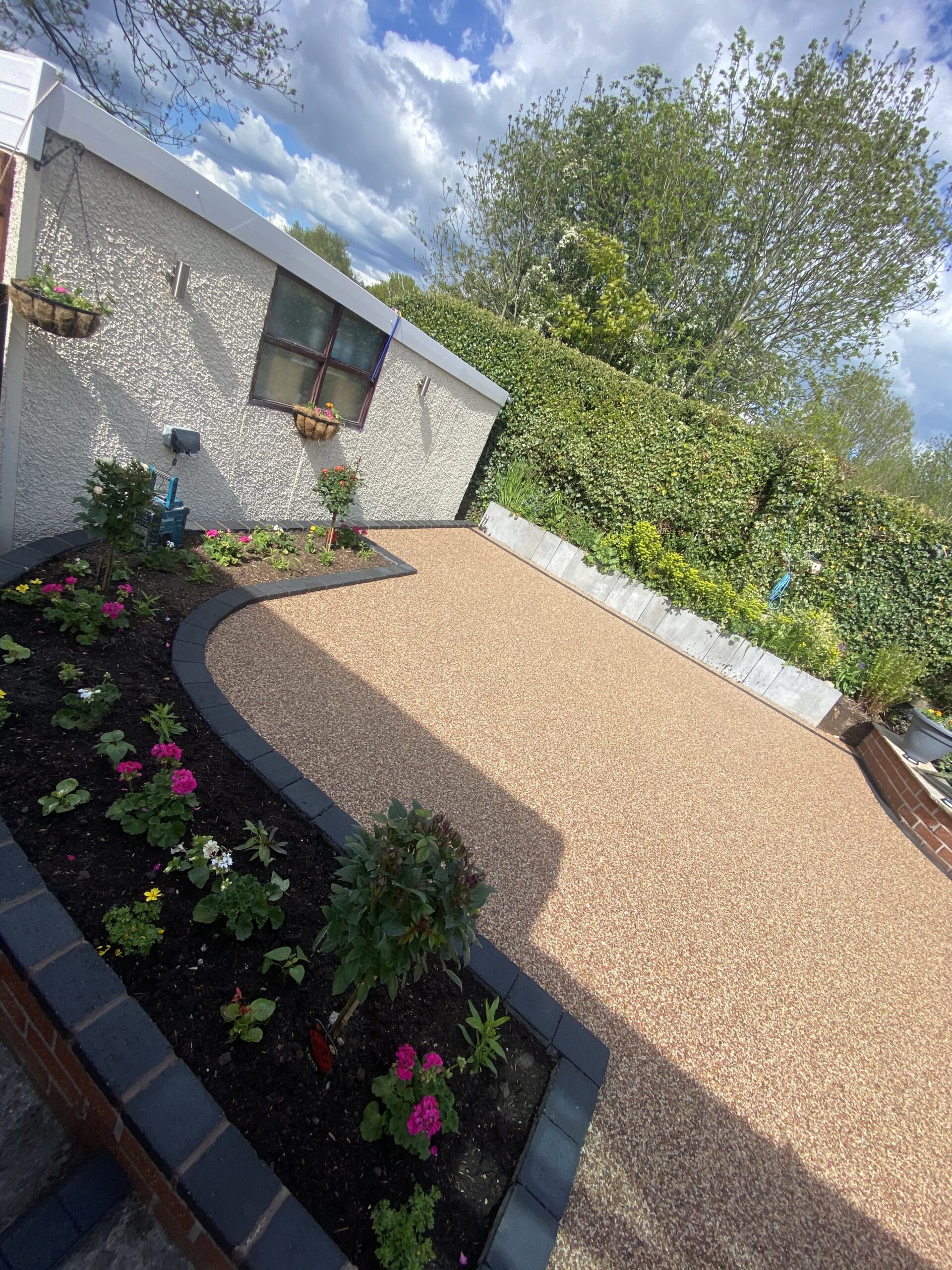 Finished Bredbury resin patio with new steps, raised flower beds and charcoal edging