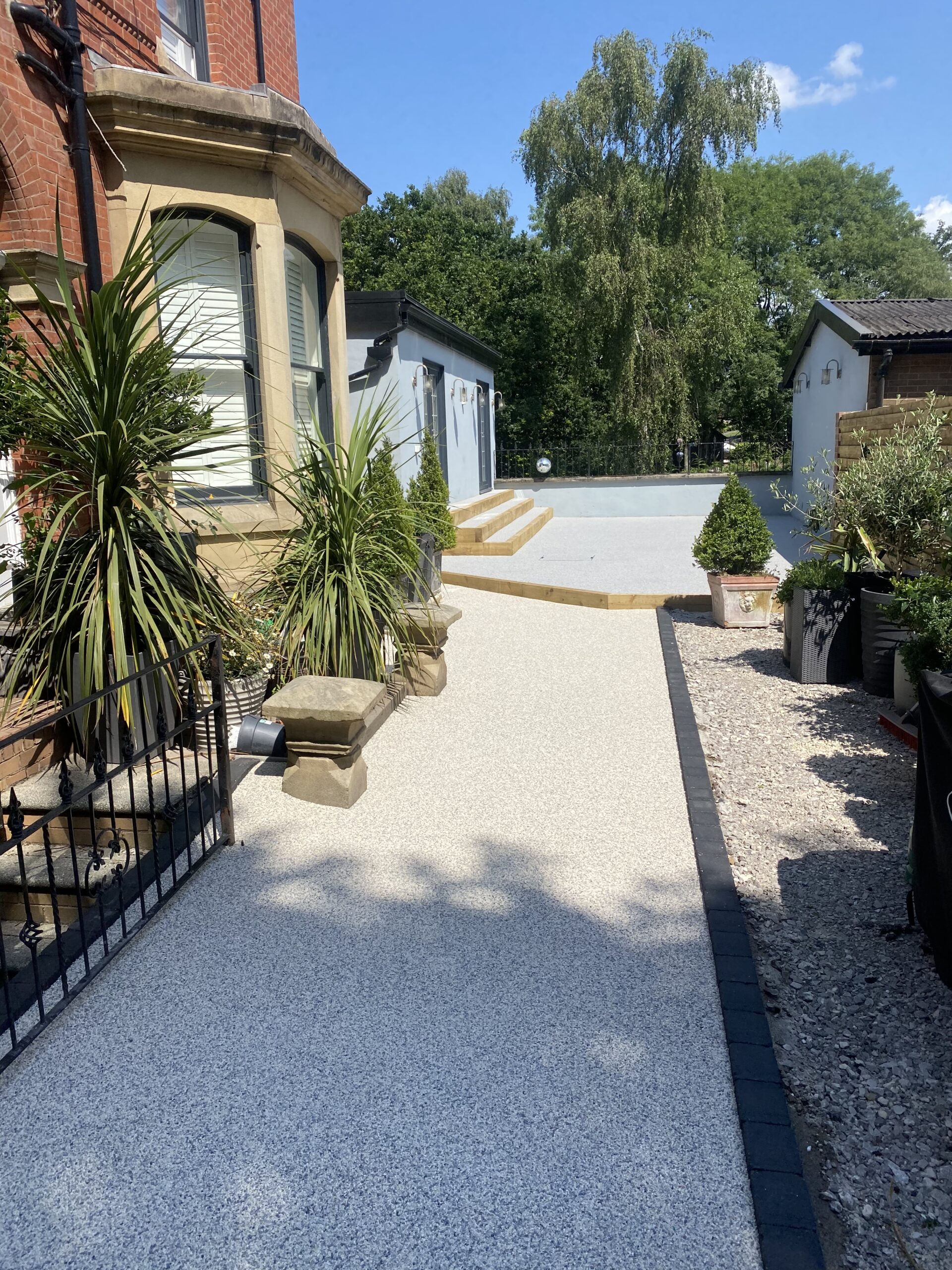 Stalybridge resin patio with artificial grass and charcoal border blocks